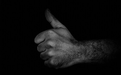 shadowed man's hand giving thumbs up sign